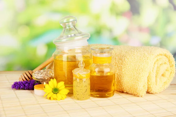 Spa au miel parfumé avec huiles et miel sur table en bois sur fond naturel — Photo