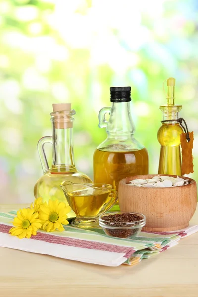 Przydatne olej lniany i olej z pestek dyni na drewnianym stole na naturalne tło — Zdjęcie stockowe