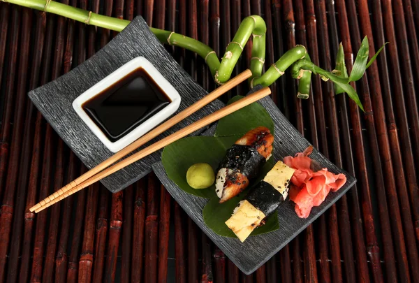 Smakelijke maki sushi - roll op plaat op bamboe mat — Stockfoto