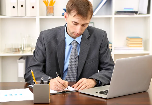 Young businessman in office at his workplace — Stock Photo, Image