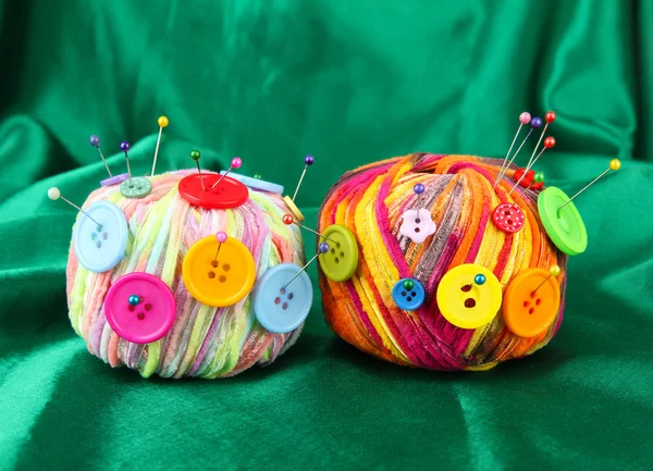 Colorful buttons and multicolor wool balls, on color fabric background — Stock Photo, Image