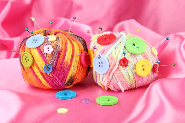 多彩按钮和多色毛球，彩色织物背景上 — 图库照片