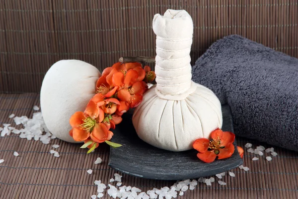Μπάλες συμπίεσης με βότανα για τη θεραπεία spa και πετσέτα σε φόντο μπαμπού — Φωτογραφία Αρχείου