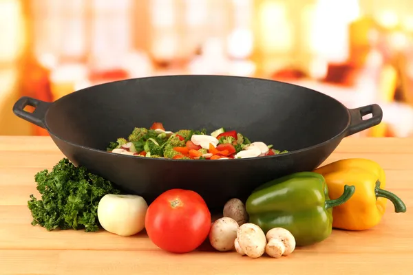 Wok with vegetable ragout on wooden table, on bright background — Stock Photo, Image