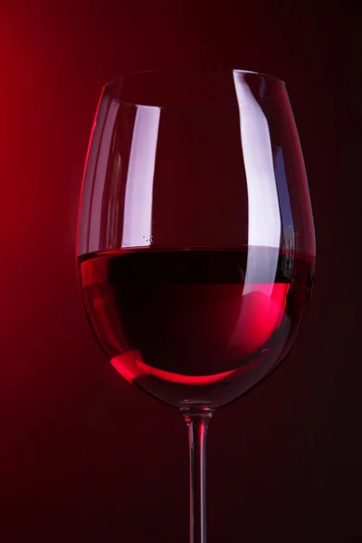 Glass of wine on bright red background — Stock Photo, Image