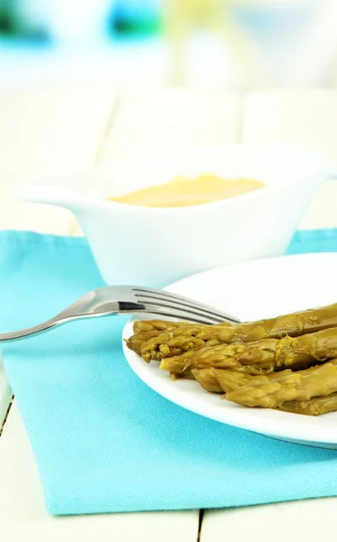 Asparagus on plate, on wooden table on bright background — Stock Photo, Image