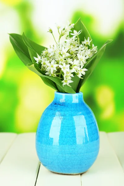 Belles jonquilles de montagne en vase de couleur, sur table en bois sur fond lumineux — Photo