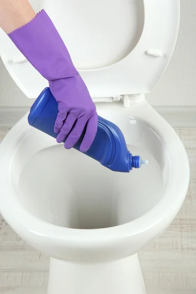 Woman hand with spray bottle cleaning a toilet bowl in a bathroom — Stock Photo, Image