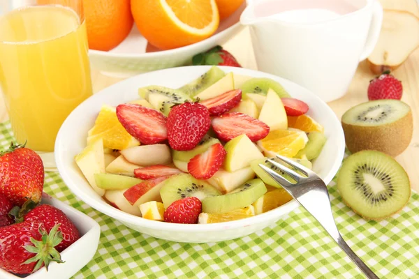 Salade de fruits utiles de fruits frais et de baies dans un bol sur une serviette sur une table en bois close-up — Photo