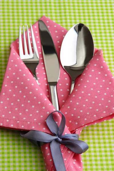 Fork spoon and knife in napkin on fabric checkered background — Stock Photo, Image