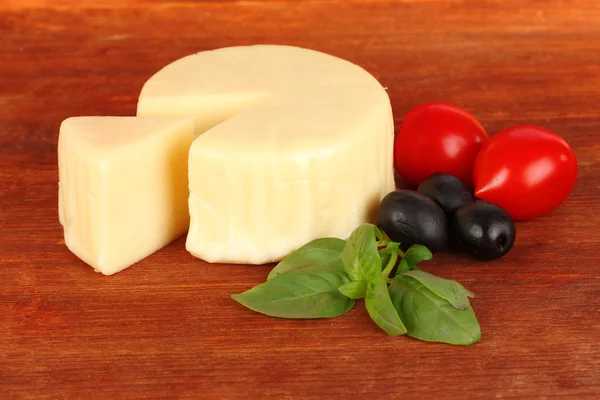 Käse-Mozzarella, Basilikum und Gemüse auf Holzgrund — Stockfoto