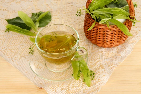 Glass cup of tea with linden on wooden table close-up — Stock Photo, Image