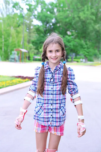 Petite fille en patins à roulettes au parc — Photo