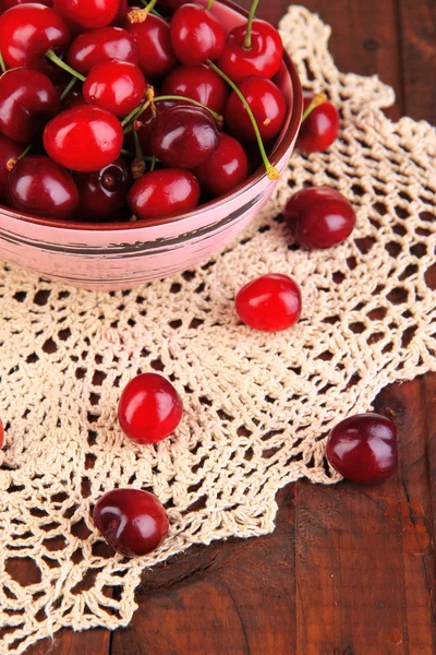 Bagas de cereja vermelhas maduras em tigela na mesa de madeira close-up — Fotografia de Stock