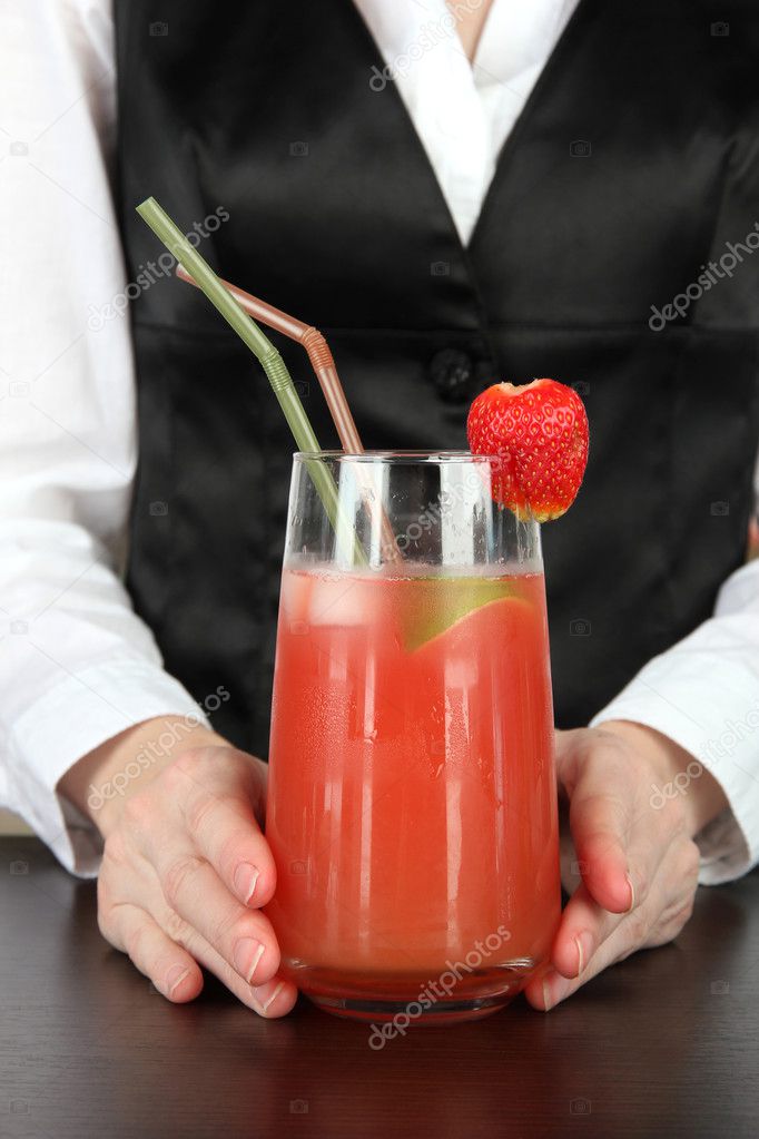 Barmen hand putting cocktail straw into glass, on bright background