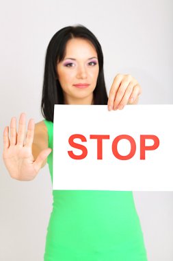 Dur işareti gri arka plan üzerinde gösterilen kız