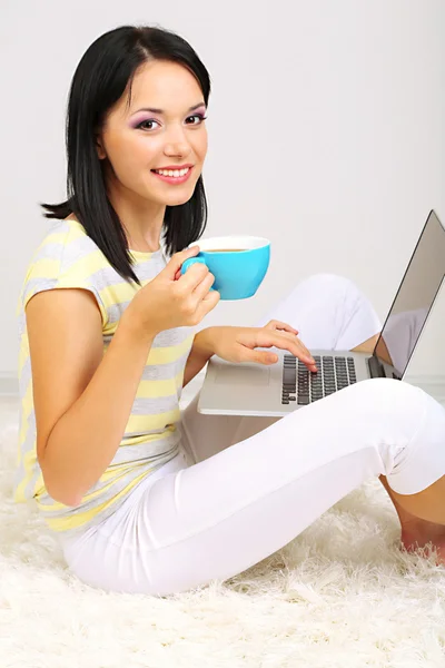 Mulher bonita sentada com notebook no quarto — Fotografia de Stock