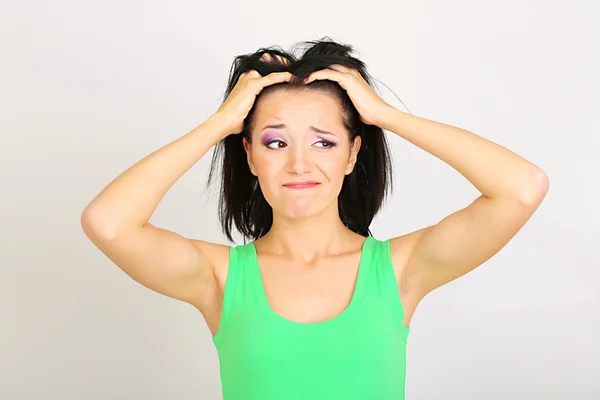 Giovane donna hanno mal di testa su sfondo grigio — Foto Stock