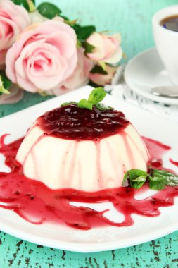 Panna cotta renk ahşap zemin üzerinde frambuaz sos ile