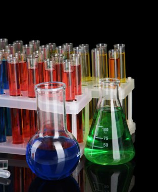 koyu arka plan üzerinde renkli test tüpleri