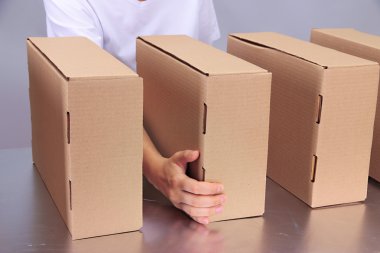 gri arka plan üzerinde Konveyör bant kutuları ile çalışan işçi