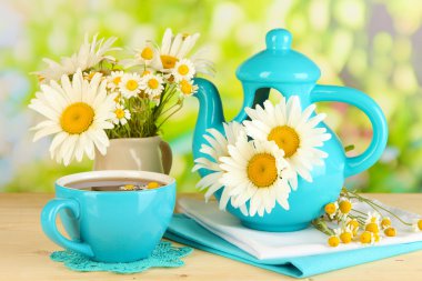 doğal zemin üzerine ahşap masa üzerinde çaydanlığın içinde güzel buket chamomiles