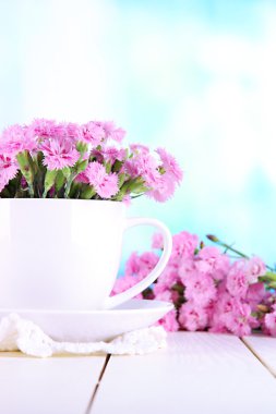 birçok küçük pembe karanfil Kupası penceresi arka plan üzerinde ahşap tablo