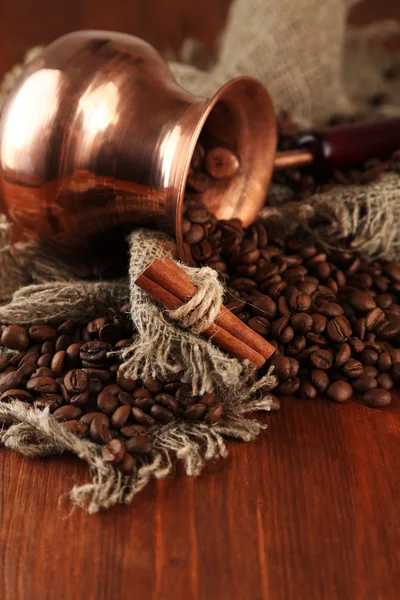 Kaffeekanne mit Kaffeebohnen auf braunem Holzhintergrund — Stockfoto