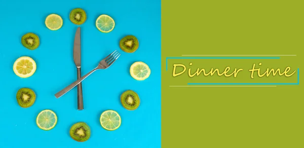 Klocka gjord av kiwi, lime och citron skivor, på färgbakgrund — Stockfoto