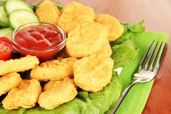 Fried chicken nuggets with vegetables and sauce on table — Stock Photo, Image
