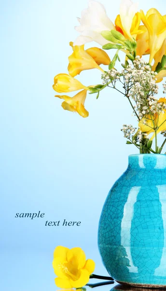 Schöner Strauß Freesien in der Vase auf blauem Hintergrund — Stockfoto