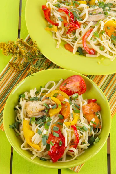 Noodles with vegetables on plates on wooden background — Stock Photo, Image