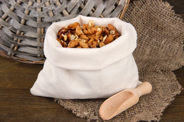 Nuts in sack on wooden background — Stock Photo, Image