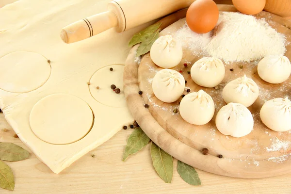 Raw dumplings and dough, on wooden table — Stock Photo, Image