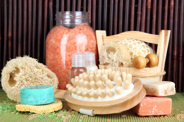 Čističi, štětec a kosmetiky pro sprchu na tabulce na bambusové pozadí — Stock fotografie