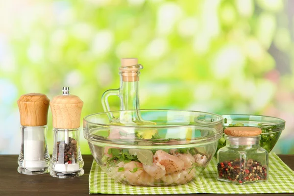 Kycklingkött i glasskål, örter och kryddor på bordet på natur bakgrund — Stockfoto