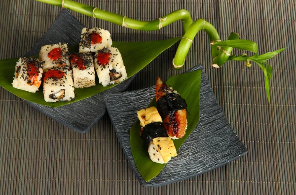 Leckeres Maki-Sushi - Rolle auf Teller auf Matte — Stockfoto