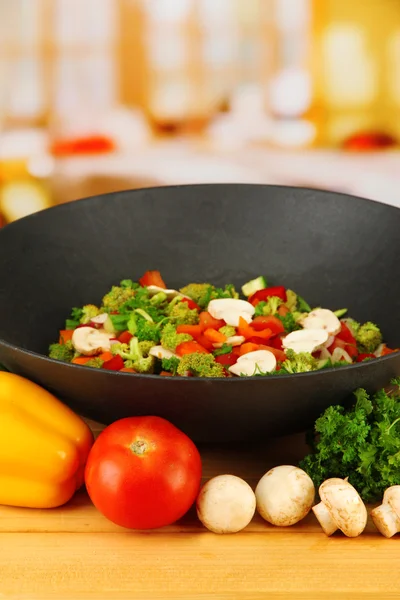 Wok med grönsaker ragu på träbord, på ljus bakgrund — Stockfoto