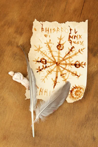 Старий папір з символами на дерев'яному фоні — стокове фото