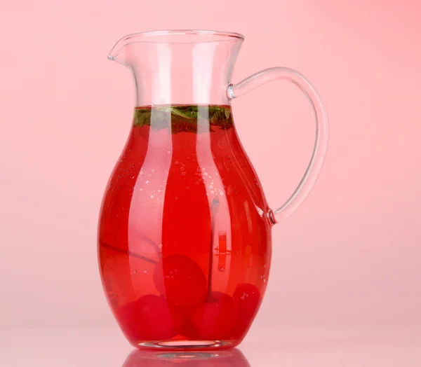 Boisson cerise en pichet sur fond rouge — Photo