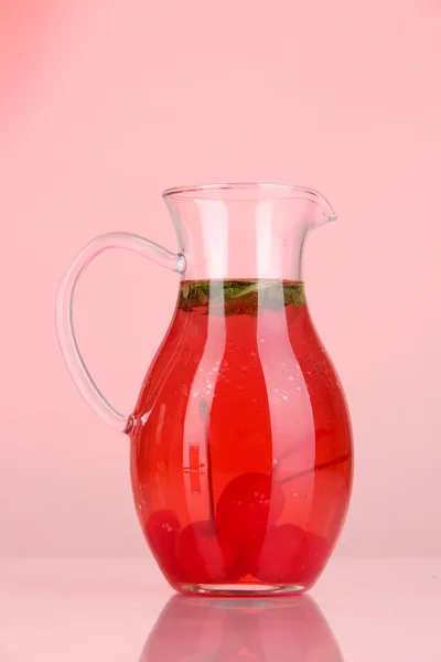 Bevanda di ciliegie in brocca su backgroun rosso — Foto Stock