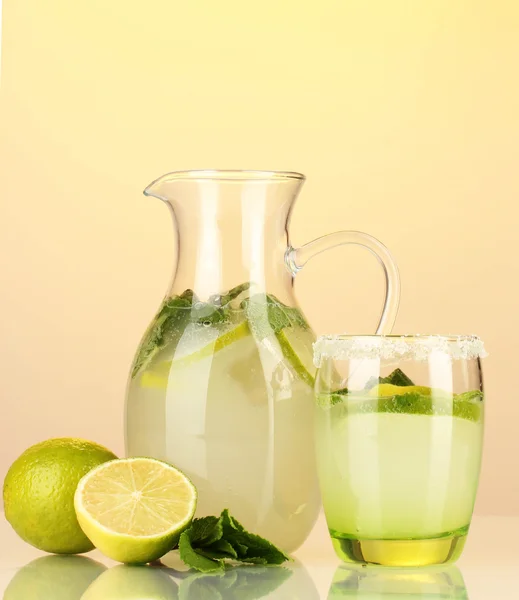 Limonade in Krug und Glas auf gelbem Hintergrund — Stockfoto