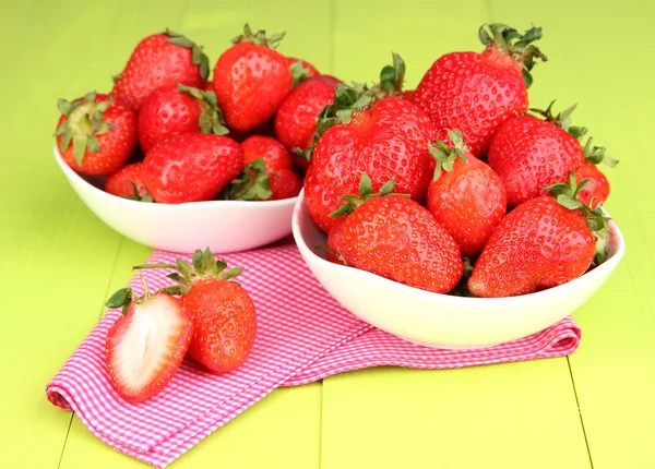 绿色木背景上的碗里的新鲜草莓 — 图库照片