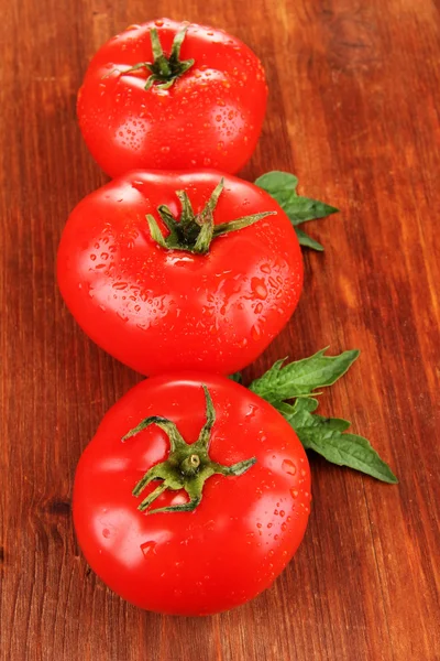 Tomates frescos sobre fundo de madeira — Fotografia de Stock