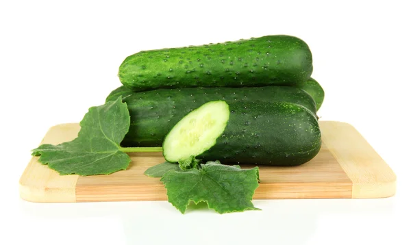 Tasty green cucumbers on wooden cutting board, isolated on white — Stock Photo, Image