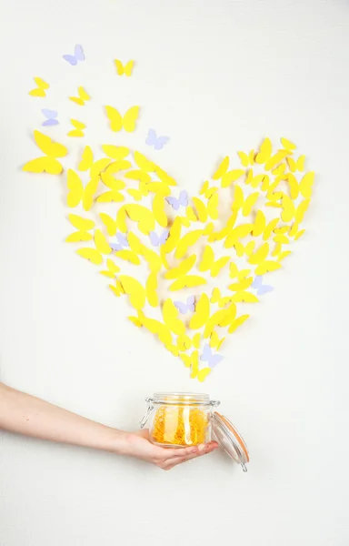 Papier gelben Schmetterling in Form von Herzen fliegen aus Bank — Stockfoto