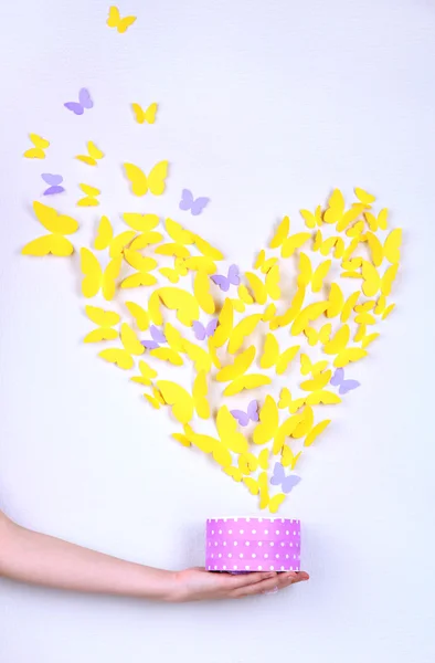 Бумажная жёлтая бабочка в форме сердца вылетает из коробки — стоковое фото