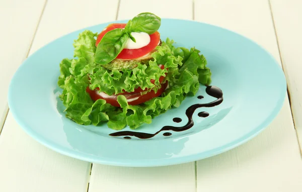 Leckere geröstete Knochenmark und Tomatenscheiben mit Salatblättern, auf Holzgrund — Stockfoto