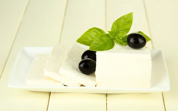 Ovčí sýr s bazalkou, olivami a rajčaty na barevné dřevěné pozadí — Stock fotografie
