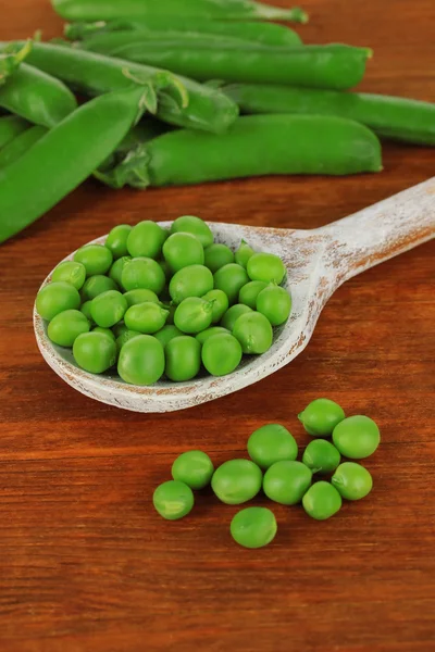 Guisantes verdes dulces sobre fondo de madera — Foto de Stock